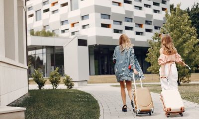 Dos mujeres con equipaje accediendo a un edificio