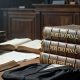 Mesa de un tribunal con códigos de derecho penal y una toga