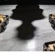 Sombra de una persona y maletines con dinero encima de la mesa