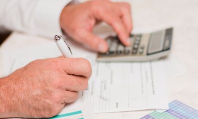 Persona usando calculadora y rellenando formularios