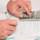 Persona usando calculadora y rellenando formularios