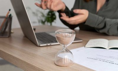 Persona con ordenador y reloj de arena