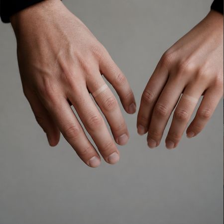 Dos manos de una pareja sin anillos