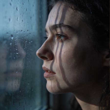 Mujer mirando por la ventana. Mirada perdida