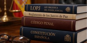 Código Penal, Constitución, LOPJ y Reglamento de los Jueces de Paz apilados en una mesa