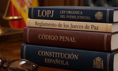 Código Penal, Constitución, LOPJ y Reglamento de los Jueces de Paz apilados en una mesa