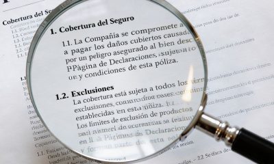 Póliza de seguro con una lupa sobre las condiciones generales y exclusiones