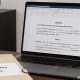 Ordenador con formulario de demanda y un expediente en la mesa denominado "Procedimiento laboral"