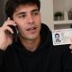 Un chico hablando por teléfono con el DNI de otra persona