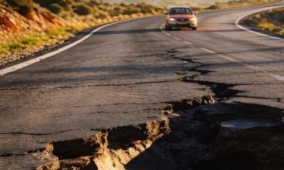 Socavón en una carretera y coche acercándose
