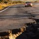 Socavón en una carretera y coche acercándose