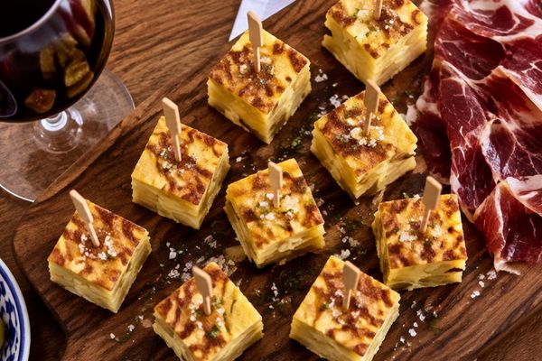 Aperitivo: jamón serrano, dados de tortilla y vaso de vino