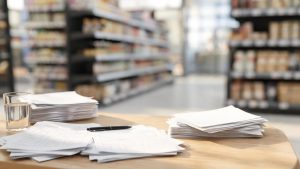 Documentos de análisis económico y laboral sobre una mesa de trabajo en un entorno empresarial.