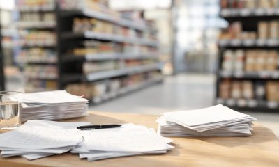 Documentos de análisis económico y laboral sobre una mesa de trabajo en un entorno empresarial.