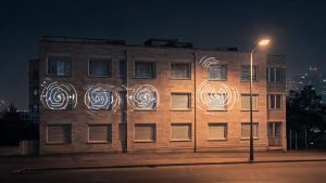 Fachada de un edificio residencial de noche iluminada por farolas urbanas
