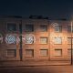 Fachada de un edificio residencial de noche iluminada por farolas urbanas