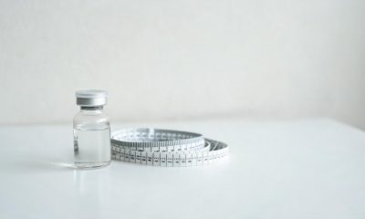 Viales médicos genéricos y una cinta métrica sobre un escritorio clínico.