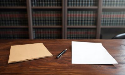 Documentos procesales y una factura sobre la mesa de un despacho de abogados.