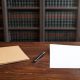 Documentos procesales y una factura sobre la mesa de un despacho de abogados.