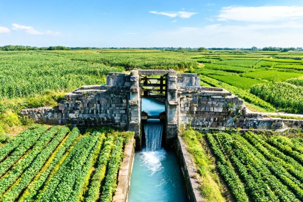 Compuerta de riego tradicional de sillería regulando el agua hacia parcelas de cultivo