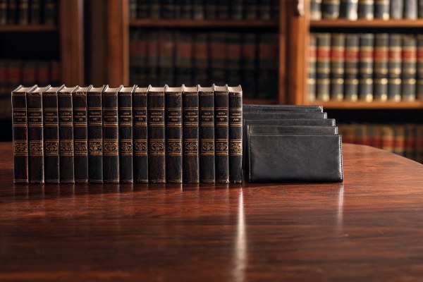 Manuales jurídicos y carpetas procesales sobre una mesa de madera de biblioteca legal.