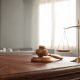 Mazo judicial de madera y balanza de la justicia sobre una mesa de despacho jurídico