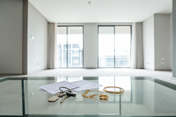 Llaves de vivienda, extractos bancarios y piezas de joyería sobre una mesa.