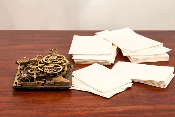 Reloj de época y documentos contractuales sobre una mesa de madera noble.