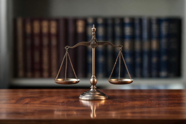 Balanza de la justicia en equilibrio sobre una mesa de madera.