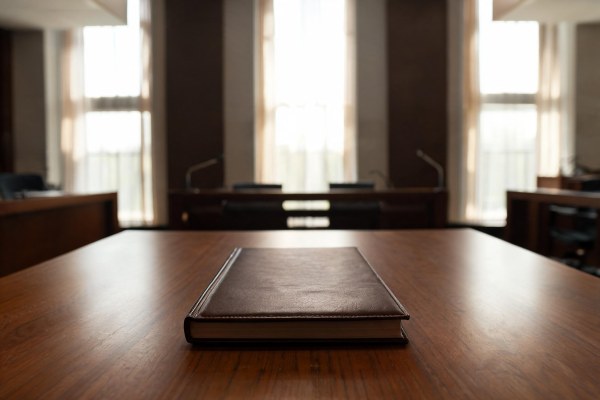 Libro de legislación constitucional sobre una mesa de estrados judiciales.