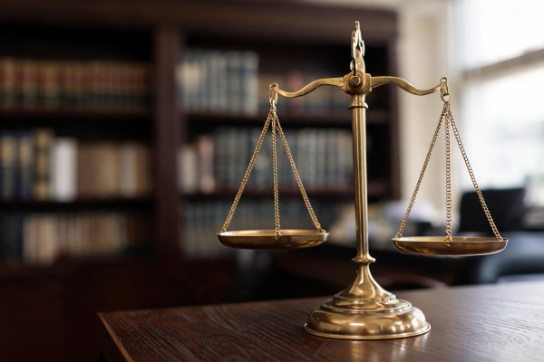 Balanza de la justicia sobre una mesa de madera en un despacho jurídico.