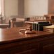 Mesa de tribunal de justicia con expedientes jurídicos y mazo de juez.