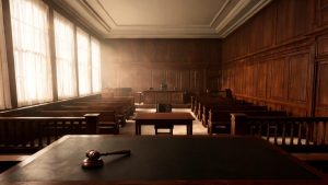 Sala de vistas judicial iluminada con mesa de estrados y mazo de madera.