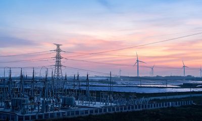 Infraestructura eléctrica y torres de alta tensión en un entorno de generación de energía renovable.