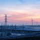 Infraestructura eléctrica y torres de alta tensión en un entorno de generación de energía renovable.