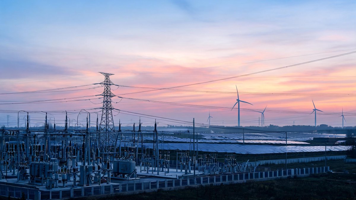 Infraestructura eléctrica y torres de alta tensión en un entorno de generación de energía renovable.