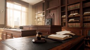 Mesa de tribunal con mazo de juez y códigos legislativos en un entorno judicial.