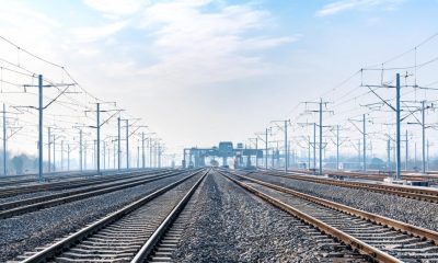 Vías de tren y catenarias en un cruce ferroviario moderno.