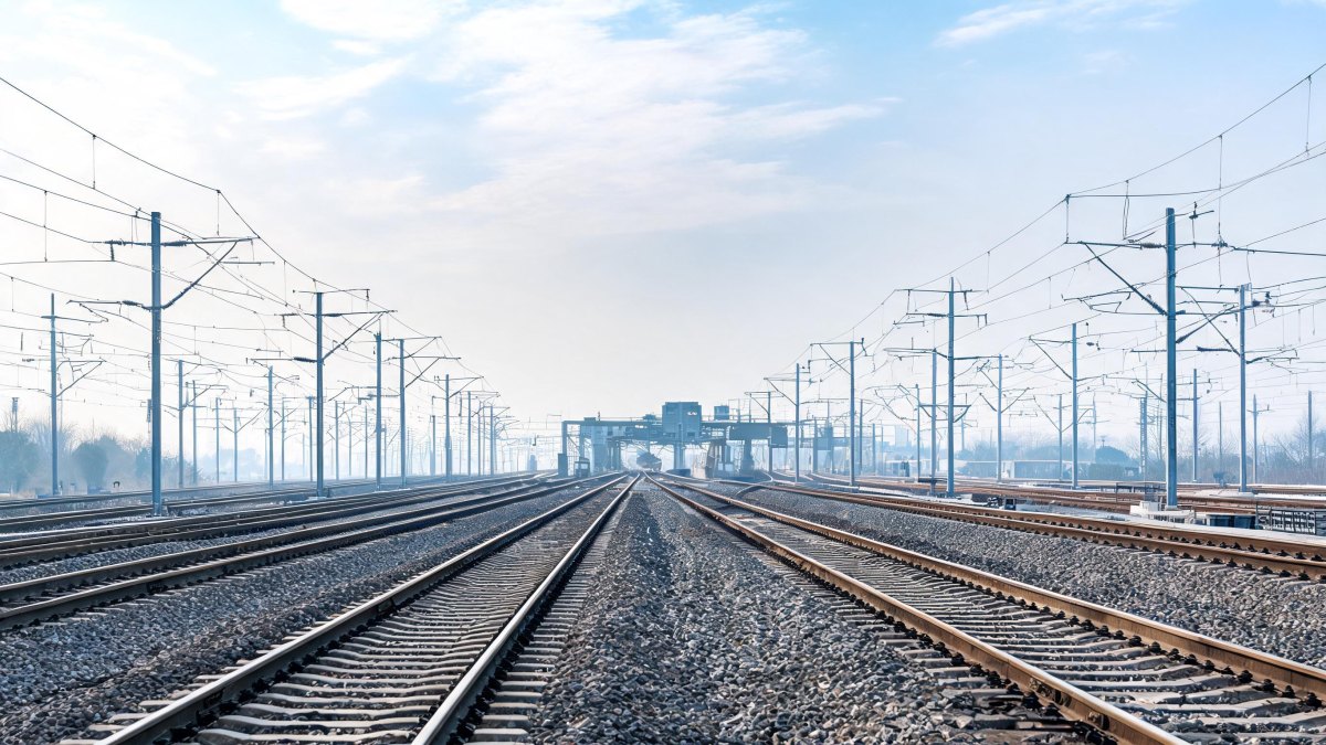 Vías de tren y catenarias en un cruce ferroviario moderno.