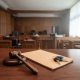Llaves de coche y mazo de juez sobre una mesa de madera en una sala de vistas judicial.