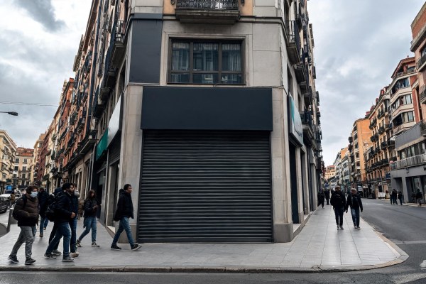 Sucursal bancaria cerrada con la persiana bajada en una calle