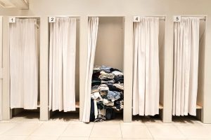Probadores de una tienda de ropa con prendas rebajadas apartadas en uno de ellos