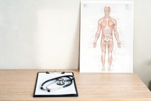 Informe médico pericial y estetoscopio sobre mesa de consulta.