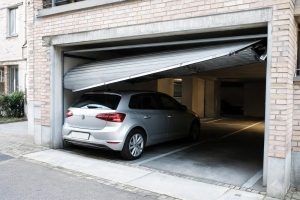 La puerta del garaje roza al abrirse el techo de un coche aparcado en la plaza contigua