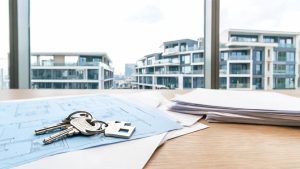 Llaves de vivienda sobre documentos y planos residenciales