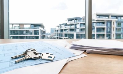 Llaves de vivienda sobre documentos y planos residenciales