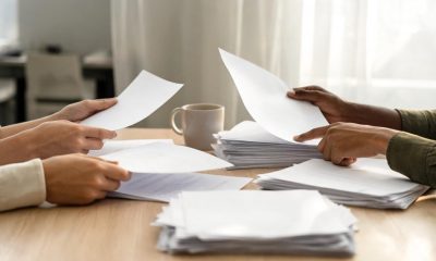 Documentos laborales y administrativos sobre una mesa de trabajo en una oficina.