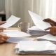 Documentos laborales y administrativos sobre una mesa de trabajo en una oficina.