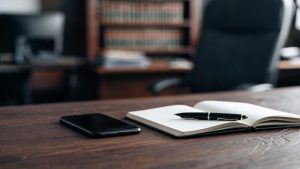 Teléfono inteligente sobre una mesa de despacho junto a documentación legal.