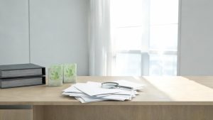 Documentos corporativos y productos con símbolos ecológicos examinados con lupa sobre un escritorio jurídico.